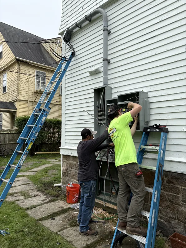 Two Toner Electric electricians working on a residential service panel